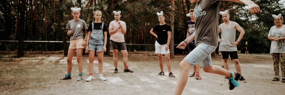 Teenagers enjoying an outdoor soccer game with a humorous twist using eyecovers as a challenge.
